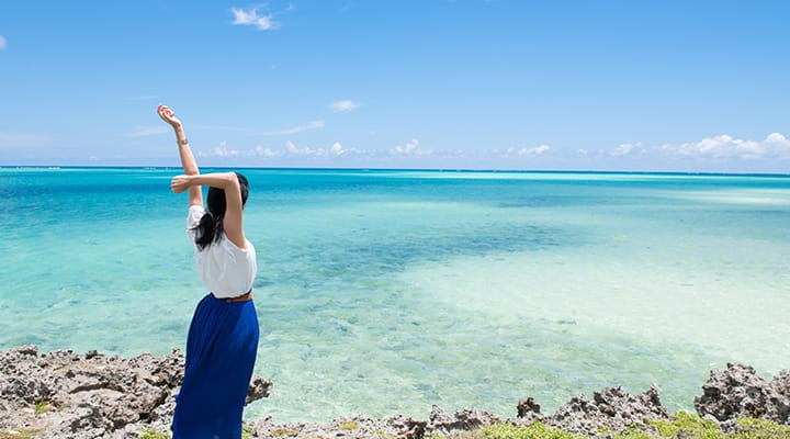 女の人が海岸の横に立っている